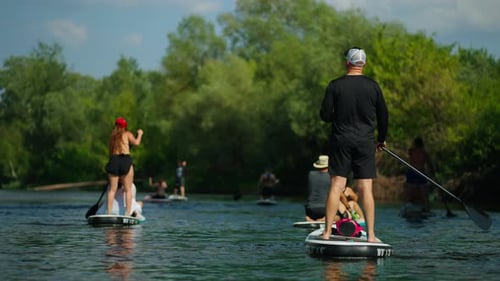 Standup Paddleboarding In River In Summer Day Athletic People Traveling And Resting In Nature