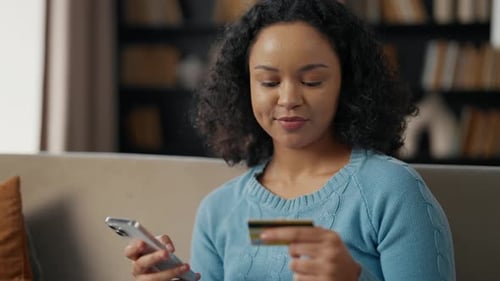 African American Woman Doing Online Payment Young Girl Buys in Internet on Smartphone Using Credit