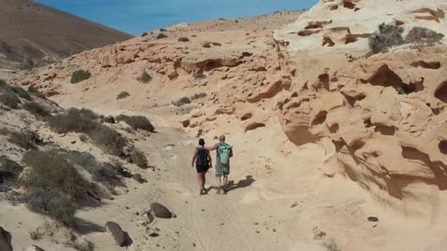 Aerial View of Couple Hiking Through Enchanted Ravine in Fuerteventura Desert