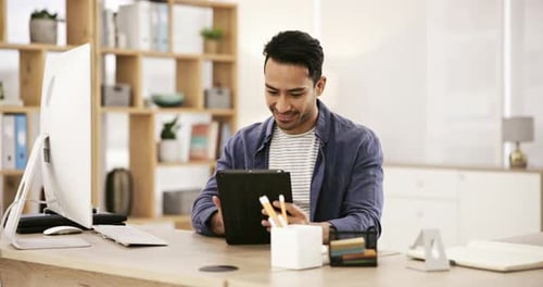 Smile, happy man at desk with computer and tablet for research for online article