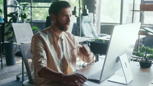 Serious Focused Professional Typing in Modern Sunlit Office