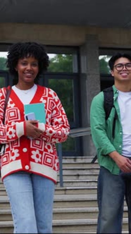 Smiling Students Stand on College Steps with Books