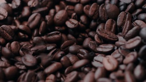 Coffee beans falling on a pile.