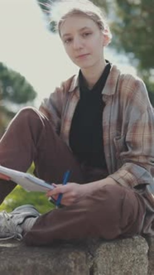 Young Woman Writing Outdoors in a Park
