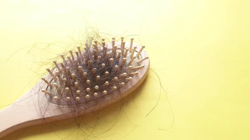 a Brush with Lost Hair on Yellow Background