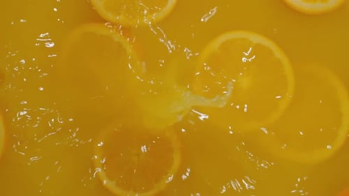 Closeup of Citrus Fruits Submerged in Sparkling Water with Bubbles and Ice Cubes