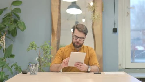 Man Working at Desk with Tablet