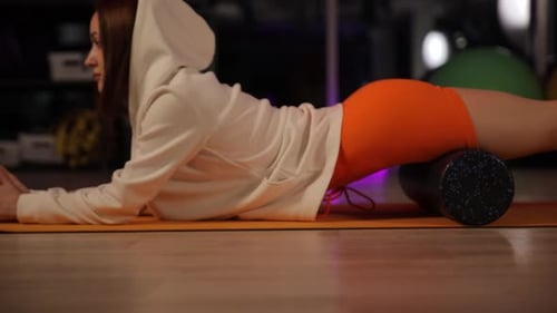 Woman Rolls Thighs in Fitness Studio