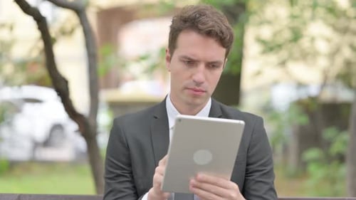 Man in Suit Using Tablet Outside