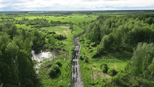 Aerial Video From Flying Drone of Siberian Landscape with Forest and Dirty Country Road After Rain