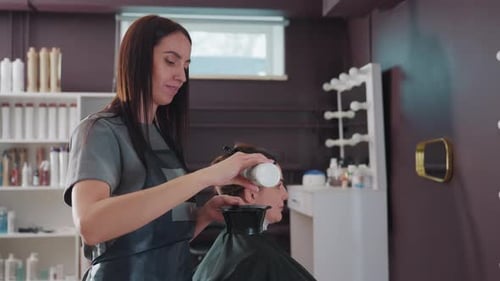 Coiffeur professionnel appliquant méticuleusement un mélange de couleurs de cheveux précis, spécialiste des cheveux caucasiens