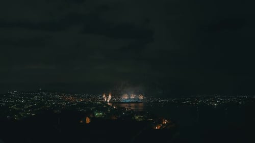 Nighttime Fireworks Display Over City Lights