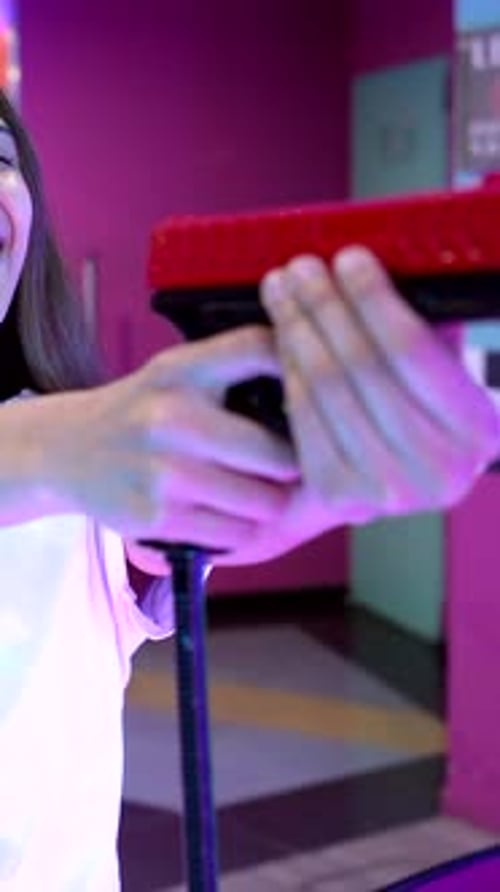 Young Woman Playing Arcade Shooting Game