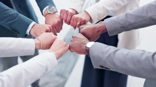 Diverse Team Fists Together in Corporate Setting