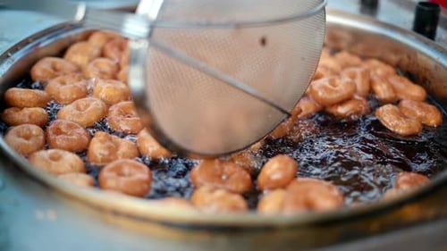 Street cook frying traditional dessert lokma in Istanbul, Turkey. Slow motion