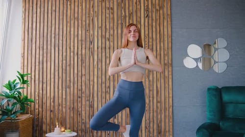Woman Practicing Yoga Tree Pose in Home Studio