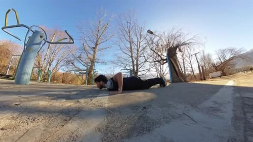 Muscular Man Doing Pushups in Outdoor Park Gym