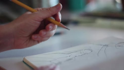 Hand Drawing Woman with Pencil on Sketch Pad