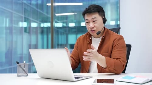 Man Wearing Headset Gesturing During a Video Call