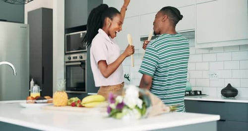 Cheerful Couple Dancing and Singing in Kitchen
