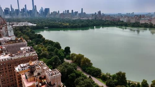 Approaching water reservoir in Central Park, New York. Sunny day footage above splendid panorama