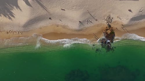 Chahue Beach in Huatulco, Oaxaca, where golden sands blend seamlessly with emerald hues of the sea
