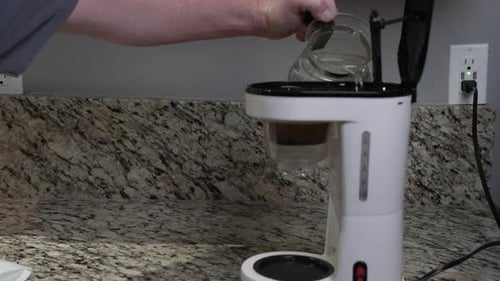 Filling Coffee Maker with Water in Kitchen
