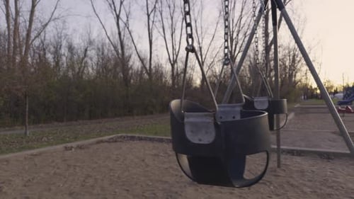 Kids swings in a playground park with no people , sadness child abuse concept