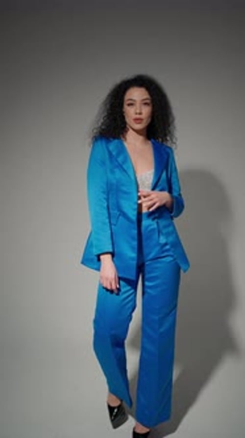 Femme en costume bleu sur fond gris Concept Style Confiance Luminosité
