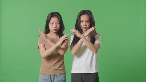 Asian Women Victims Of Violence Showing Hands Cross Gesture To Stop Violence In Green Screen