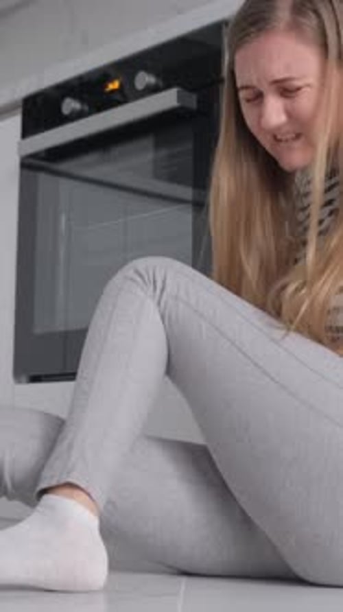 Der monatliche Zyklus einer Frau Sie sitzt und umarmt ihre Knie, fühlt Verzweiflung und Angst Einsamkeit vertikal