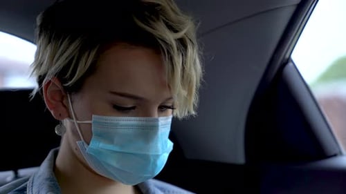 Woman Wearing a Surgical Mask in a Car