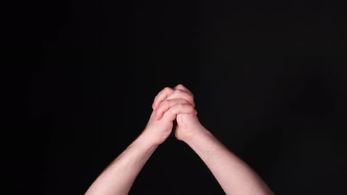 Clasped Hands in Front of a Black Backdrop