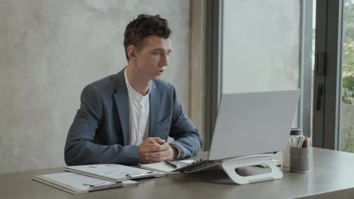 Man on Video Call Showing Charts