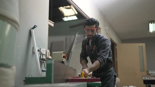 Carpenter is working at workshop.