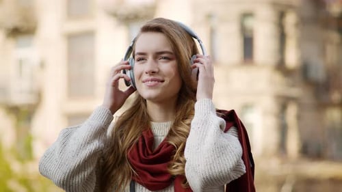 Woman Enjoys Music with Headphones in the City