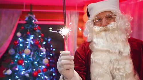 Cheerful Santa Claus Holding a Lit Sparkler Indoors