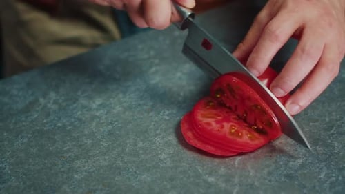 Slicing a Ripe Red Tomato with Sharp Knife