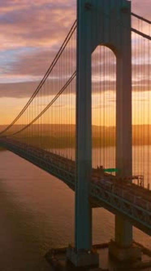 Calm waters of East River at setting sun. Beautiful construction of Whitestone bridge