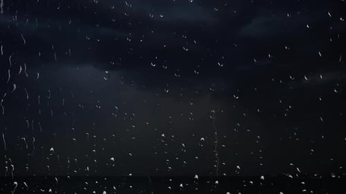 Relâmpagos no céu noturno entre nuvens de trovoada. Gotas de chuva no vidro da janela
.