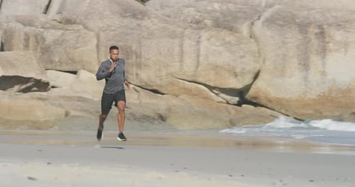 4k video footage of a young handsome man working out at the beach