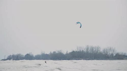 Kitesurfer Riding On Extreme Sea Wave With Fall Season Background. wide shot, slow motion