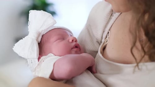Gentle Care: Newborn Held Affectionately by Parent Indoors