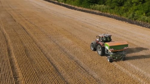 Aerial View of Farmer Fertilizing Agricultural Field Spreading Mineral Fertilizer in Slow Motion