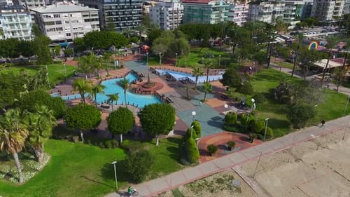 Aerial Video of a Coastal Sports Facility Featuring Beach Volleyball Tennis Courts and a Playground