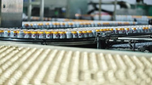 Thousands of cans of beverages moving through a factory
