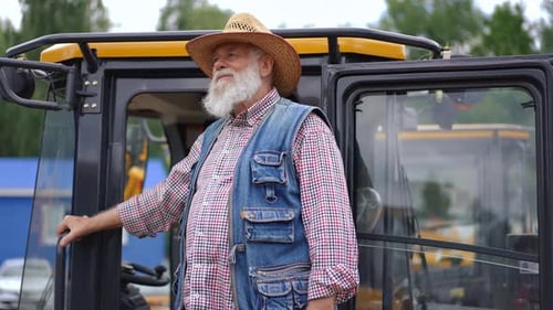 Senior Man Stands Next to Tractor Gives Thumbs Up