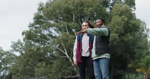 Camping, happy couple and pointing to forest, view or nature, relax and talking together