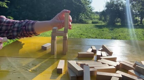 Woman builds a tower with wooden blocks as an analogy of balance life