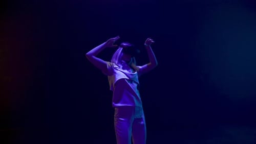 Woman Dancing with VR Headset in Dark Room